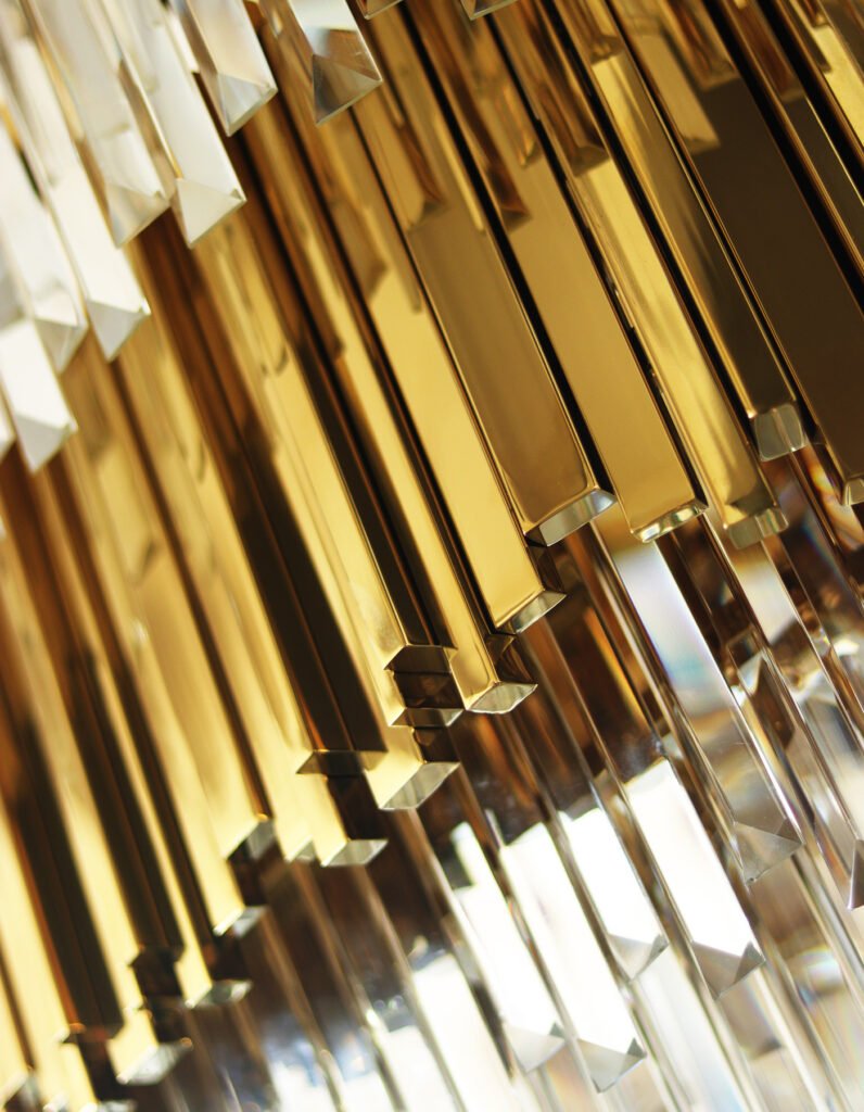 Close-up of polished brass profiles and faceted crystal lighting elements