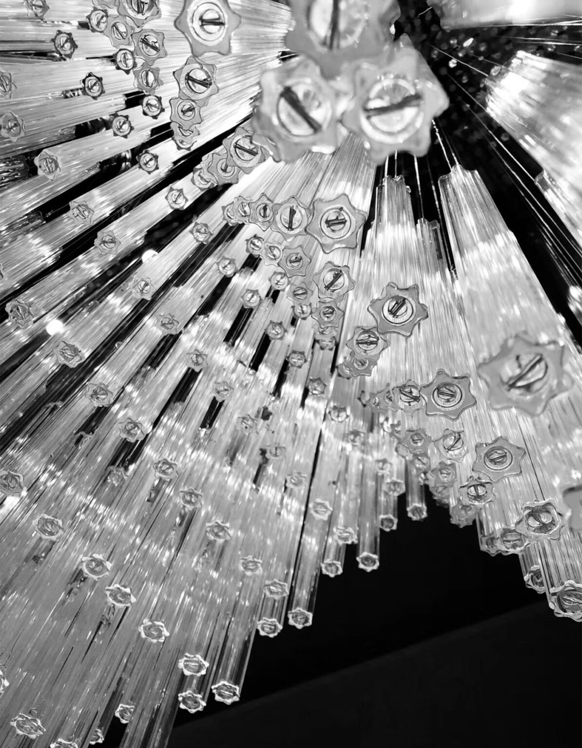 Monochrome close-up of crystal rods and precision lighting assembly hardware