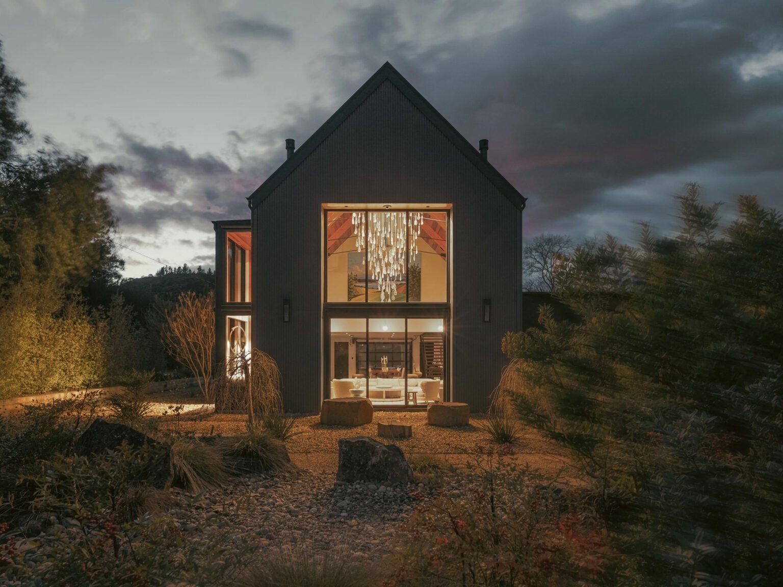Contemporary residence illuminated at dusk with a statement chandelier