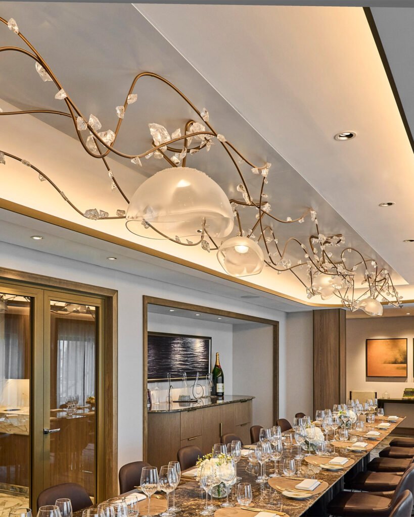 Sculptural branch lighting installation above an elegant dining table