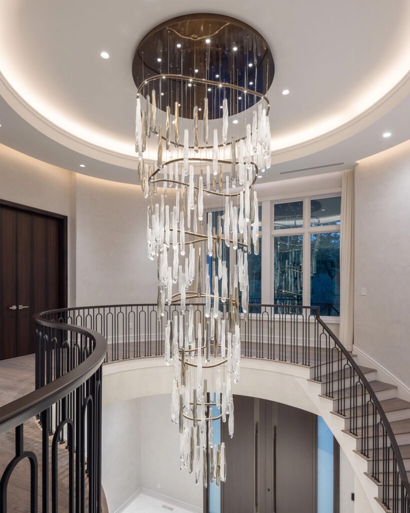Cascading glass chandelier within a double-height residential staircase